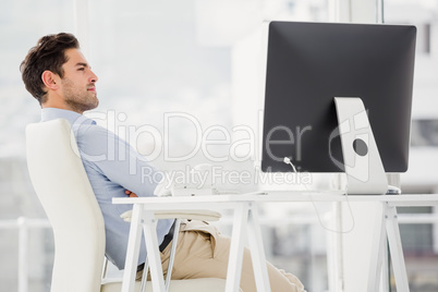 Businessman sitting with arms crossed in the office