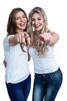 Portrait of two beautiful woman pointing towards camera