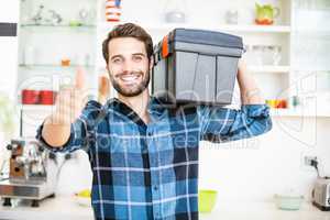 Man carrying tool box giving thumbs up