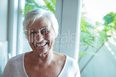 Portrait of senior woman against window