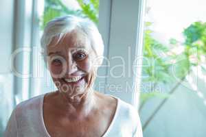 Portrait of senior woman against window