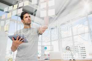 Man holding digital tablet and looking at sticky notes