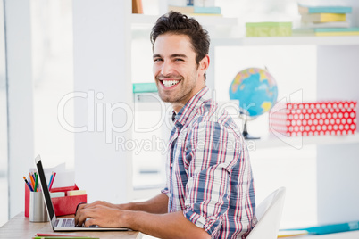 Young man using laptop at his desk