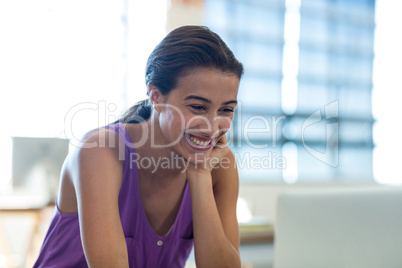 Young woman sitting at desk using laptop