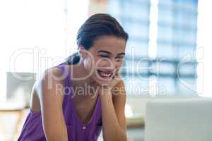 Young woman sitting at desk using laptop