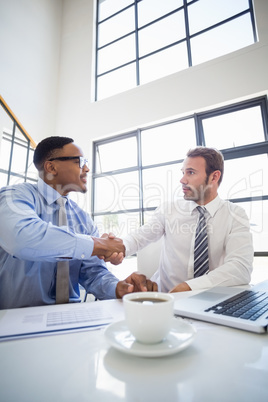 Businessmen shaking hands in office