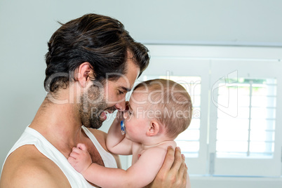 Happy father with baby boy in bedroom