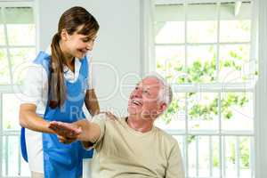 Smiling nurse assisting aged man
