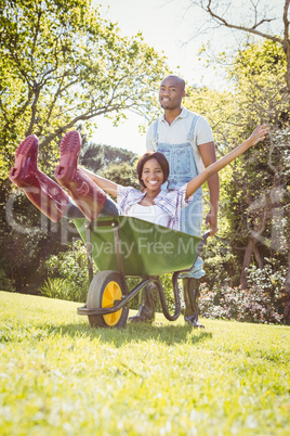 Young man giving woman a ride in the wheelbarrow