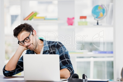 Stressed young man sitting at his desk