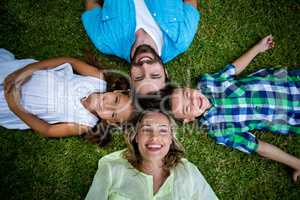 Happy family lying on grass in yard