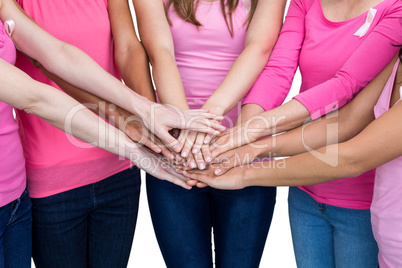 Women in pink outfits joining in a circle for breast cancer awar