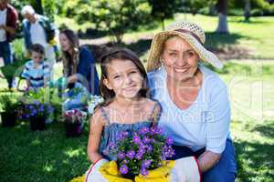 Grandmother and granddaughter holding a flower pot while gardeni