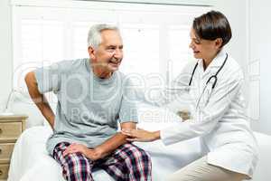 Smiling female doctor assisting senior man