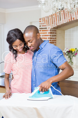 Young couple ironing clothes