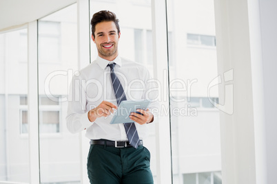 A man is holding a notebook and smiling