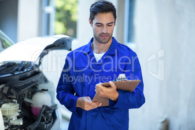 Front view of technician checking clipboard