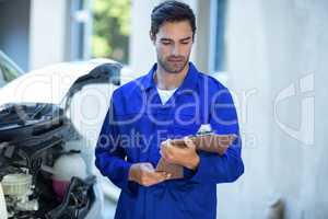 Front view of technician checking clipboard