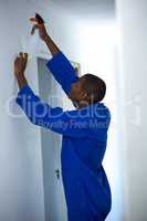 Handyman spraying insecticide on wall