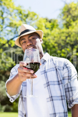 Young man holding wine glass in the garden