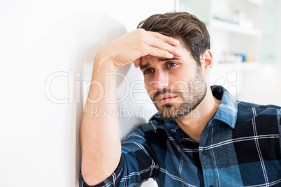 Depressed man leaning on wall