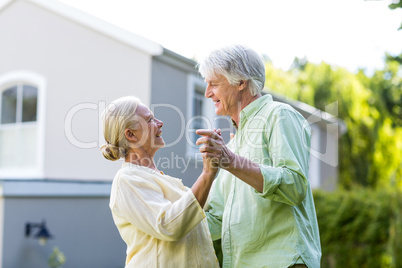 Couple dancing in yard against house