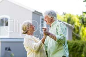 Couple dancing in yard against house