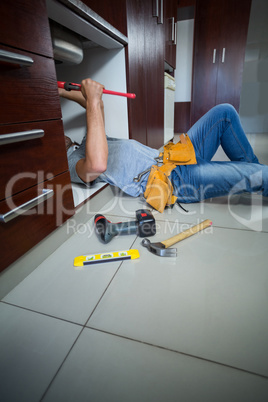 Midsection of man using pipe wrench