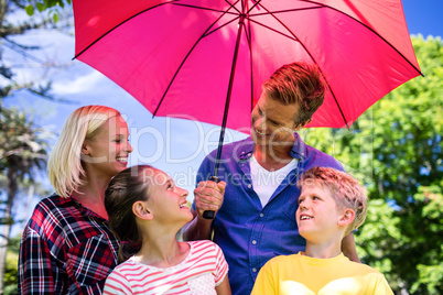 Family standing under umbrella