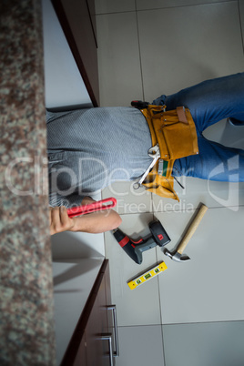 Low section of man working while lying