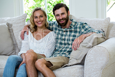 Portrait of happy young couple on sofa