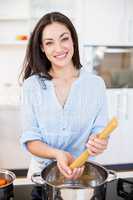 Woman preparing spaghetti noodles in kitchen