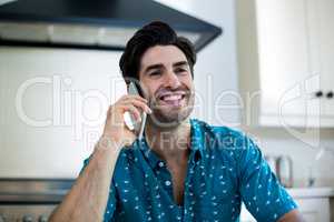 Man talking on phone in kitchen