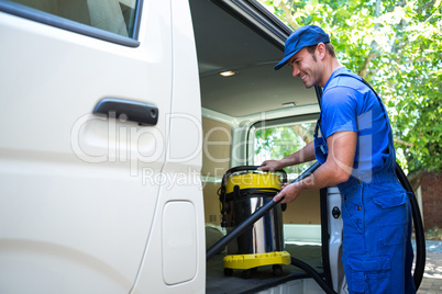 Happy janitor cleaning the car