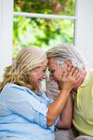 Romantic senior couple emracing while sitting on sofa