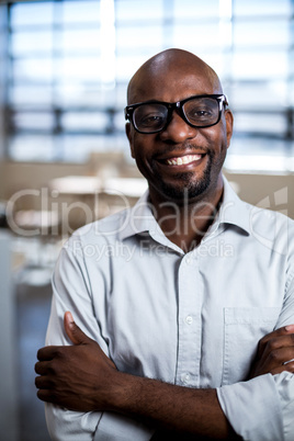 Man with arms crossed smiling at camera