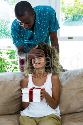 Man giving a surprise gift to her woman