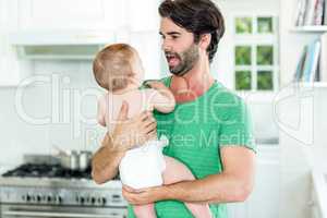 Father playing with son in kitchen