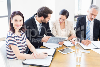 Workers are looking at their notes and one of them are smiling a