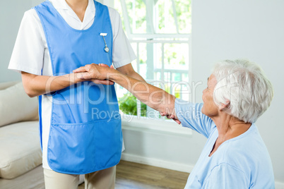 Midsection of nurse assisting senior woman