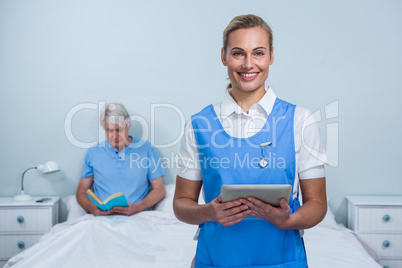 Smiling nurse holding digital tablet at hospital