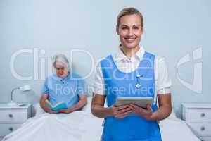 Smiling nurse holding digital tablet at hospital