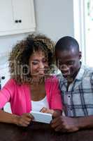 Couple using mobile phone in kitchen