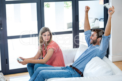 Smiling man with arms raised after winning video game