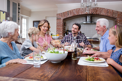 Woman serving food to her family in the kitchen