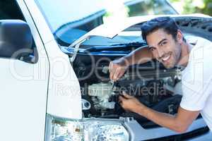 Portrait of happy mechanic fixing van