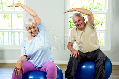 Portrait of smiling senior man and woman exercising