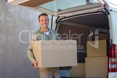 Happy delivery man carrying a cardboard box