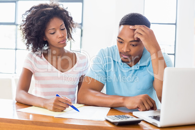 Worried young couple discussing bills