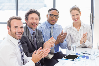 Businesspeople applauding while in a meeting